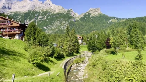 Small stream in the greenery and high rocky mountains. Stock Footage 249661992