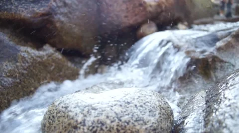 Small Stream over rocks with hikers in background. Stock Footage 66491645