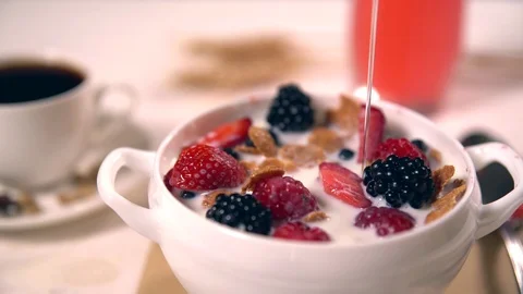 Small stream of syrup pouring on cereal bowl Stock Footage 93916366