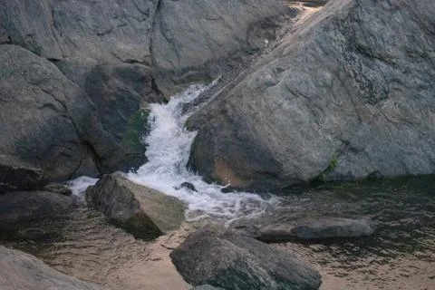 Small stream of water flowing through the rocks Stock Photos