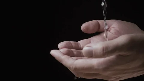 A small stream of water flows into men's hands. Slow motion Stock Footage 74761773