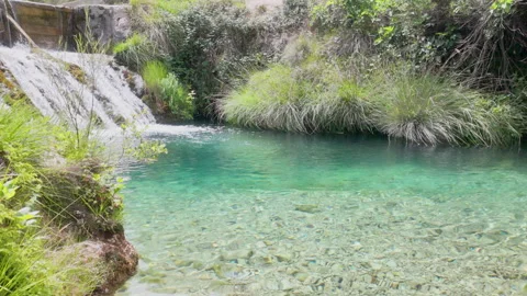 A small stream of water flows over a rock Stock Footage 277410339