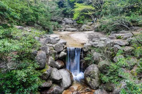 A small stream of water flows through a rocky area Mount Misen zen garden Stock Photos
