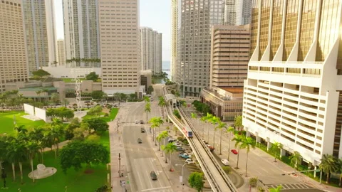 Small subway train moving in the middle of the sunny city downtown lit Stock Footage 224891331