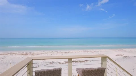 Small summer balcony with two chairs revealing magnificent ocean view with Stock Footage 247702420