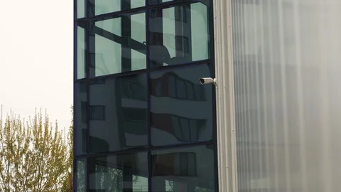 Small surveillance camera on the office building near big windows Stock Footage 106028143