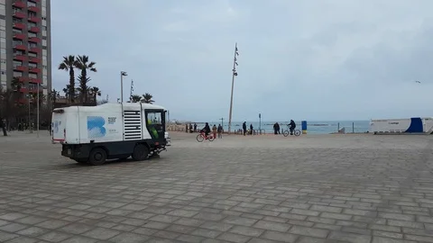 A small sweeper cleans the pavement from the sand on the promenade. Stock Footage 123720980