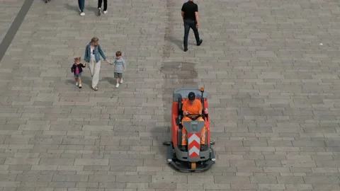 A small sweeper with two front brushes cleans the square during the day Stock Footage 221554494