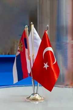 Small table flags of Turkey Serbia and other countries on international fair Stock Photos