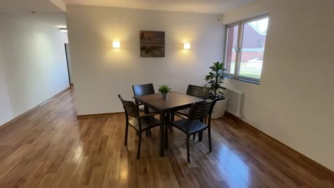 Small table in a hotel with white walls a parcel and a hallway Vidéo 236992116