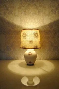 A small table lamp, with a yellow light on the bedside table 스톡 사진