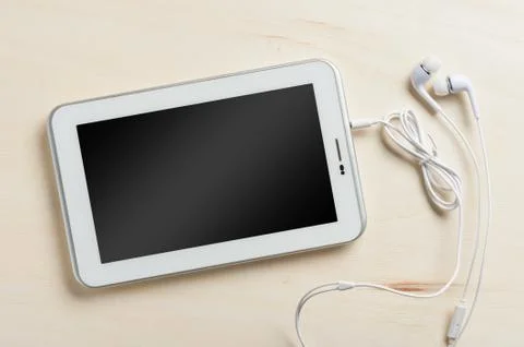 Small tablet pc with in ear headset Stock Photos