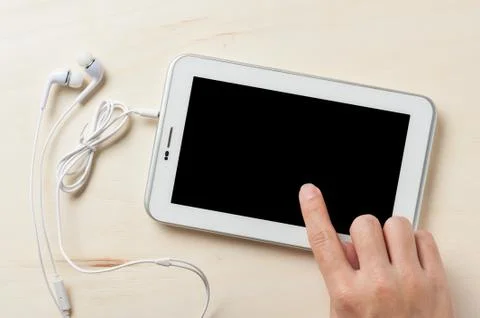 Small tablet pc with in ear headset Stock Photos