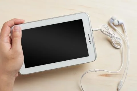 Small tablet pc with in ear headset Stock Photos