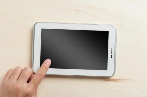 Small tablet pc on wood table Stock Photos