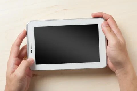 Small tablet pc on wood table Stock Photos