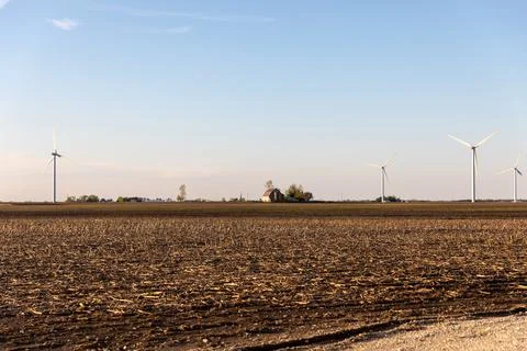 Small Tan Barn in Row of Wind Turbines Stock Photos