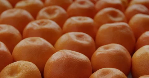 Small tangerines background. Selective focus, table spin, seamless loop. Stock Footage 277607707