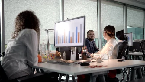 Small Team of Young Professionals Having a Conversation While Working Late Stock Footage 143699640