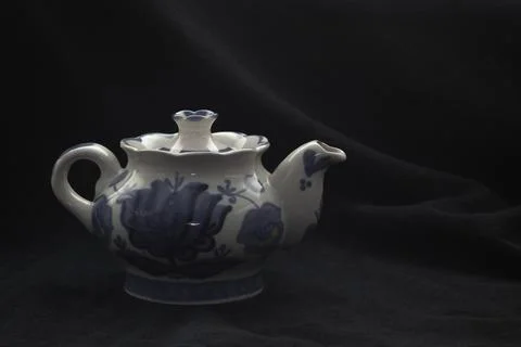A small teapot on a black background Stock Photos