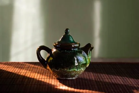 A small teapot for tea brewing on table in sunlight Foto stock