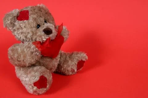 Small teddy bear on red background Stock Photos