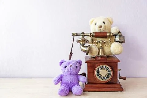 Small teddy bears around stylish vintage telephone on table Stock Photos