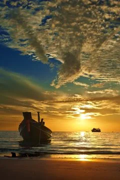 Small Thai boat at tropical sunset Stock Photos