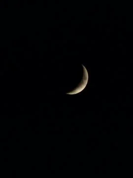 Small thin crescent moon in dark night sky. Stock-Fotos