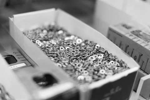 Small thin metal nails, hardware, screw lying in a store container. Foto stock
