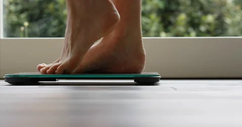 Small, thin woman's feet get on and off a bathroom scale Stock Footage 157799757