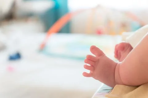 The small tiny cute feet of the infant. Blurred light background Stock Photos