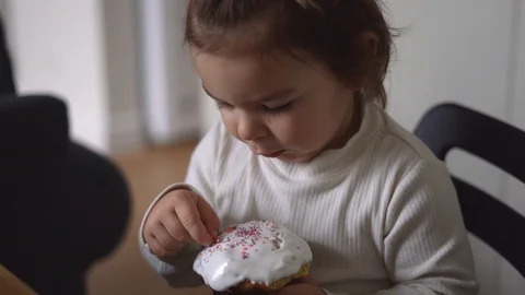 A small toddler girl eating Easter cake for Orthodox Easter Stock Footage 128756793
