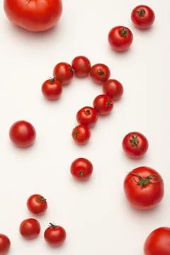 Small tomatoes arranged into a question mark, surrounded by different sized Stock Photos