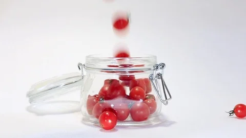 Small tomatoes falling down in the bowl on a white background Stock Footage 115775337