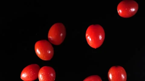 Small tomatoes fly into the air. Slow motion. Macro mode. Close-up. Black backgr Stock Footage 271732740