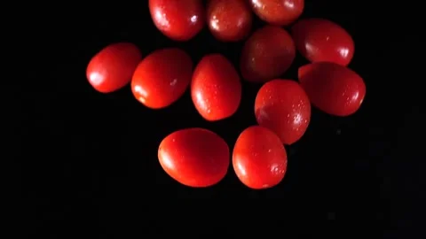Small tomatoes fly into the air. Slow motion. Macro mode. Close-up. Black backgr Stock Footage 271732742