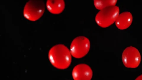 Small tomatoes fly into the air. Slow motion. Macro mode. Close-up. Black backgr Stock Footage 271732753