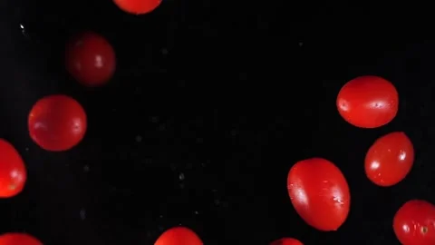 Small tomatoes fly into the air. Slow motion. Macro mode. Close-up. Black backgr Stock Footage 271732772