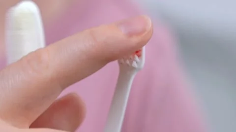 Small toothbrush in cup by mirror in bathroom at home Stock Footage 244685689