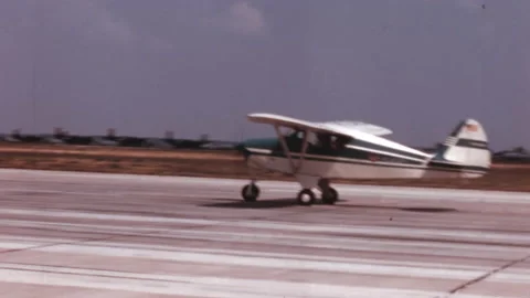 Small touring plane takes off from a paved runway in a video from the 1950s Stock Footage 169164788