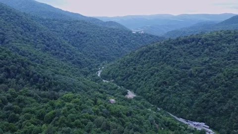 Small town in a canyon surrounded by mountains and forestry, aerial shot 動画素材 311775273