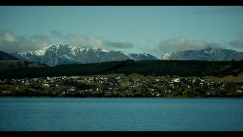 Small town at lake with mountains in the background Stock Footage 270213442