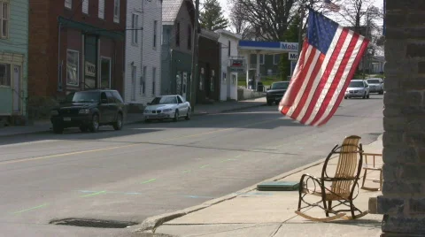 Small Town Main Street USA With Flag Flying From A Store Stock Footage