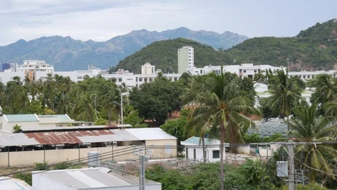 Small town with palms in cloudy day on mountains background. Tropical concept Stock Footage 114056200