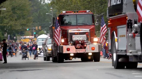 Small town parade with fire trucks and floats while people throw candy at Stock Footage 96664539