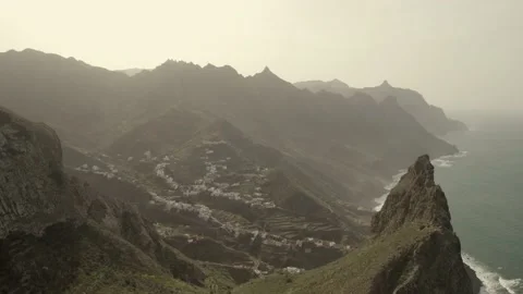 Small town surrounded by rocks on the shores of a green island Stock Footage 133067392
