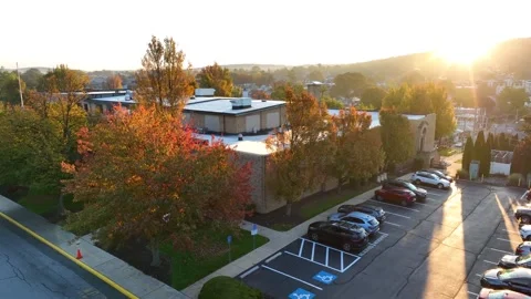 Small town in USA school building. Aerial in autumn. Golden hour light. Stock Footage 259836633