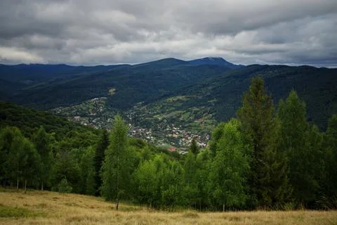 Small town in a valley between mountains, against the background of pine tree Stock Photos