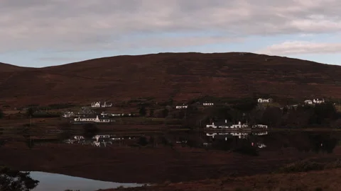 Small Town on the Watersedge with Specular Reflection. Achill Island, Ireland Stock Footage 239548187